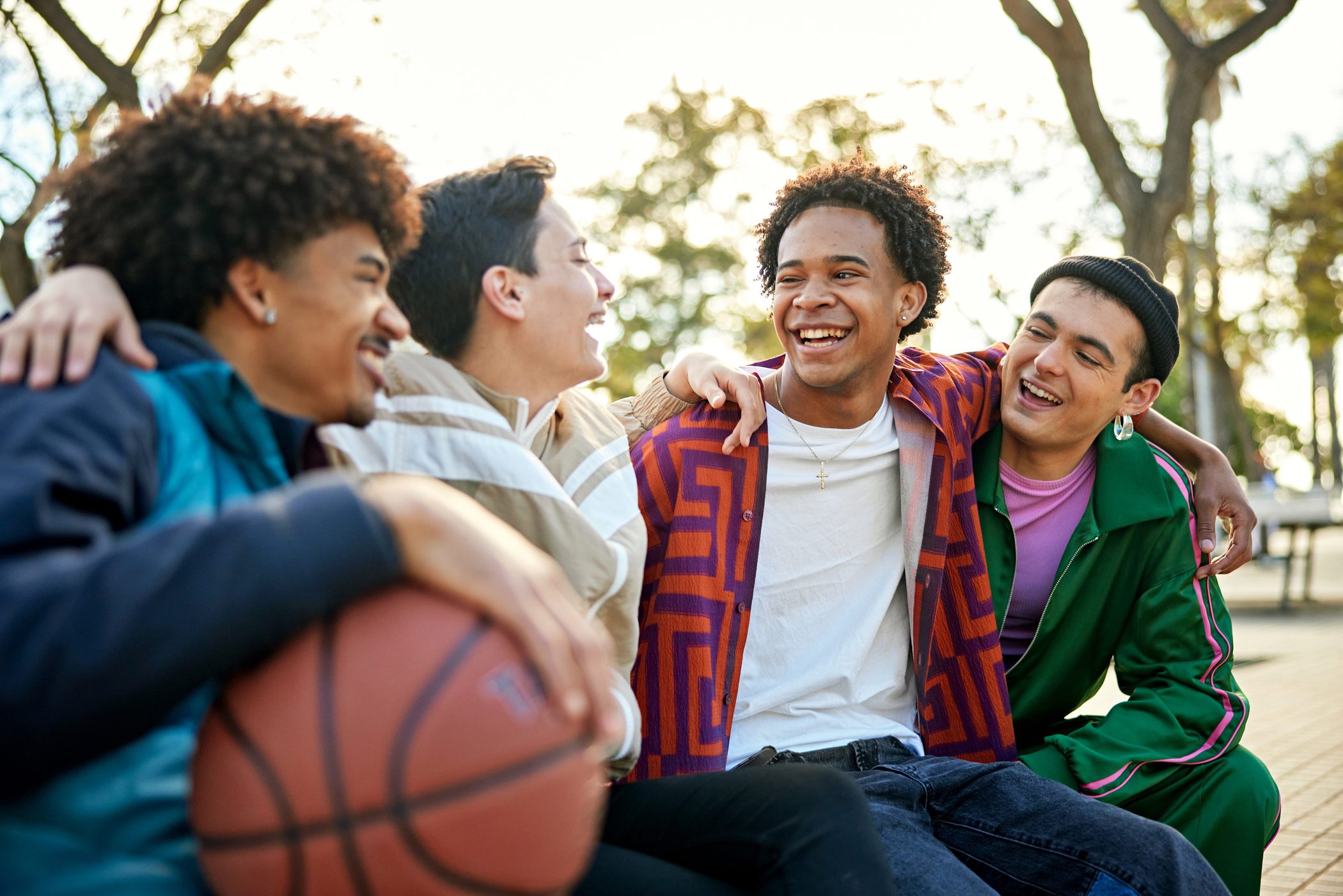 Group of teen boys spending time together in the park on a sunny day.